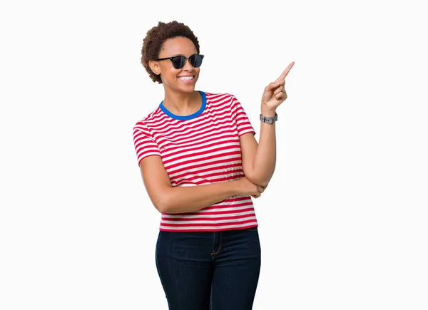 美丽的年轻非洲裔美国妇女戴着太阳镜在孤立的背景与一个很大的微笑在脸上 用手和手指指着一边看着镜头 — 图库照片