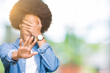 Genç Afrikalı-Amerikalı adam elleriyle gözlerini kapsayan afro saçlı ve stop jest ile acı ve korku ifadesi. Utandım ve negatif kavramı.