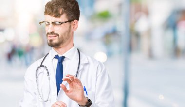 Genç doktor adam izole arka plan mide bulandırılmış ifade üzerinde hastane ceket giyiyor, nefret ve korkuya acı yüz yapıyor çünkü kaçınma reaksiyon. Ellerle kaldırdı. Rahatsız edici kavramı.