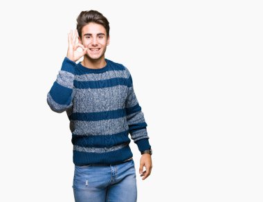 Gülümseyen izole arka plan üzerinde genç yakışıklı adam el ve parmaklar ok işaretiyle yapıyor olumlu. Başarılı ifade.