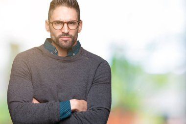 İzole arka plan şüpheci ve sinir, onaylamayan ifade yüz çapraz kolları üzerinde gözlük takan yakışıklı delikanlı. Negatif kişi.