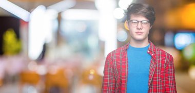 Genç yakışıklı öğrenci adam yüzünde ciddi bir ifade ile izole arka plan üzerinde gözlük takıyorum. Basit ve doğal kameraya bakıyor.