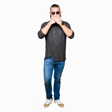 Genç hipster adam ağız hata için elleriyle kapsayan şok güneş gözlüğü takıyor. Gizli kavramı.