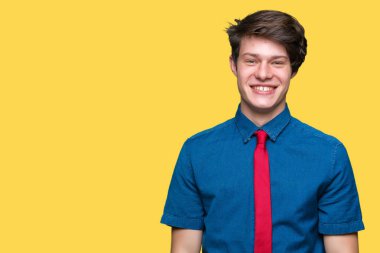 Yüz üzerinde mutlu ve serin bir gülümseme ile izole arka plan üzerinde kırmızı kravat giyen genç yakışıklı iş adam. Şanslı kişi.