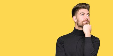 Genç yakışıklı sarışın giyen kış kazak çene düşünme hakkında soru, dalgın ifade üzerine el ile dostum. Düşünceli yüzüyle gülümsüyor. Şüphe kavramı.