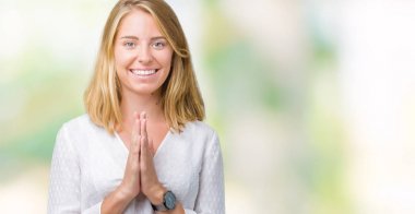 Birlikte emin gülümseyen bağışlanmak ellerle dua izole arka plan güzel genç zarif kadın.