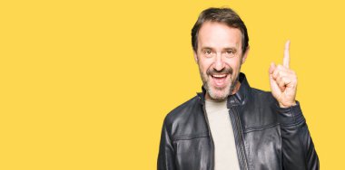 Orta yaş yakışıklı adam siyah deri ceket giyen başarılı bir fikir ile parmak yukarı işaret. Çıkıldı ve mutlu. Bir numara.