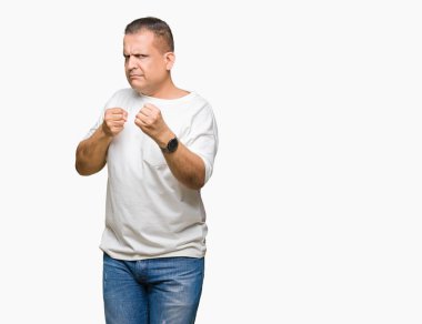 Orta yaş Arap adam wearig izole arka plan üzerinde beyaz t-shirt yumruk savunma hareketi, kızgın ve üzgün yüz, sorunu korkuyor ile savaşmaya hazır