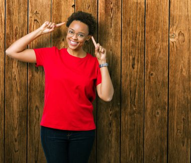 Hem el parmak, harika bir fikir ya da düşünce, iyi bellek ile baş gösteren gülümseyen güzel genç Afro-Amerikan kadın gözlük izole üzerinde arka plan