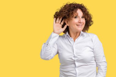 Bir işitme söylenti ya da dedikodu için dinleme kulak üzerinde el ile gülümseyen izole arka plan güzel orta ager üst düzey businees kadın. Sağırlık kavramı.