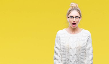 Korkuyor ve şok sürpriz ifade, korku ve heyecan yüz ile izole arka plan üzerinde gözlük takan genç güzel sarışın kadın.