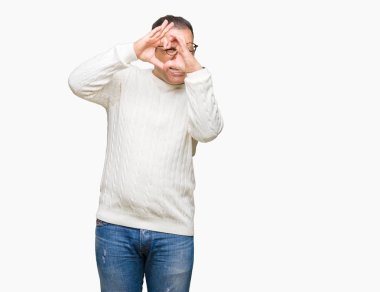 Orta yaş Arap adam izole arka plan yaparken kalp şekli el ve parmak işareti seyir gülümseyen ile üzerinde gözlük