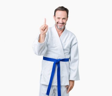 Yakışıklı orta yaş komuta sizde kimono üniforması ve parmak gülümseyen süre bir numara ile kendinden emin ve mutlu yukarıyı gösteren izole arka plan üzerinde.