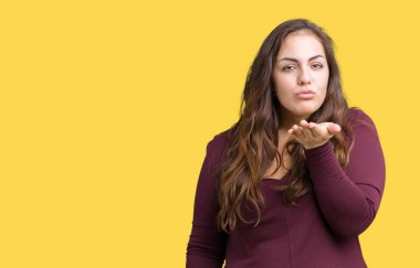 Güzel ve çekici bir öpücük el ile güzel ve seksi olmak hava üfleme kamera bakarak izole arka plan üzerinde elbise boyutu genç kadın artı. Aşk ifade.