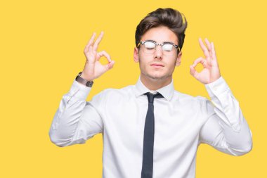 Genç iş adamı gözlük izole arka plan üzerinde dinlenmek ve gülümseyen gözlerle kapalı parmak jestle meditasyon yapıyor. Yoga kavramı.