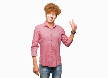 Mutlu yüz zafer işareti yaparken kameraya göz kırpıyor ile gülümseyen afro saçlı Genç yakışıklı iş adamı. İki numaralı.