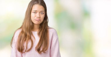 İzole arka plan üzerinde pembe kış kazak giyen genç güzel esmer kadın depresif ve kızgın ve korkmuş ağlıyor sıkıntı için endişeleniyorum. Üzgün ifade.