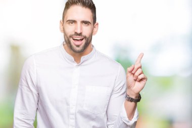 Kameraya bakarak yan el ve parmak ile işaret eden genç iş adamı yüzünde kocaman bir gülümseme ile izole arka plan üzerinde.