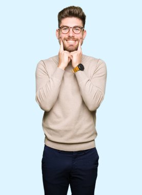 Gözlük giyen genç yakışıklı iş adamı açık ağız ile gülümseyen, parmaklar işaret ve neşeli gülümseme zorlayarak