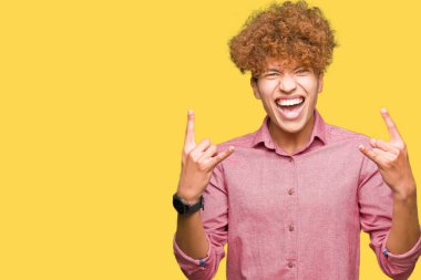 Genç yakışıklı iş adamı deli ifade rock simge elle yapıyor ile bağırarak afro saçlı. Müzik yıldızı. Ağır kavramı.