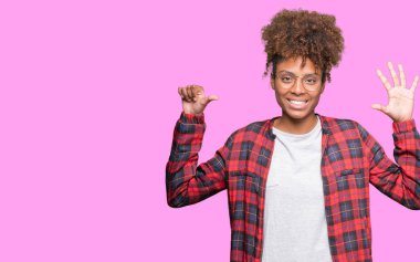 Güzel genç Afro-Amerikan kadın gözlük gösterilen ve parmakları ile işaret izole arka plan üzerinde kendinden emin ve mutlu gülümseyerek süre 6 numara.