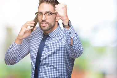 Genç iş adamı izole arka plan üzerinde telefonda konuşurken kızgın ve sinirli öfke, deli ve yükseltilmiş el, öfke kavramı ile bağırarak