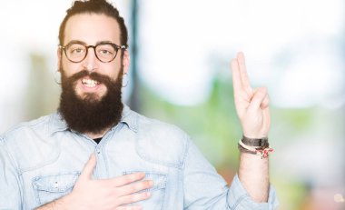 Uzun saç ve sakal giyen genç hipster adamla Swearing göğüs ve parmaklar, el ile bir sadakat sözü yemin yapma gözlük