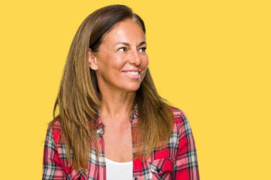 Orta yaş yetişkin kadın üzerinde rahat gömlek giymiş arka plan uzak tarafına gülümseme ile yüzünde, doğal ifade arıyorum izole. Kendine güvenen gülüyor.