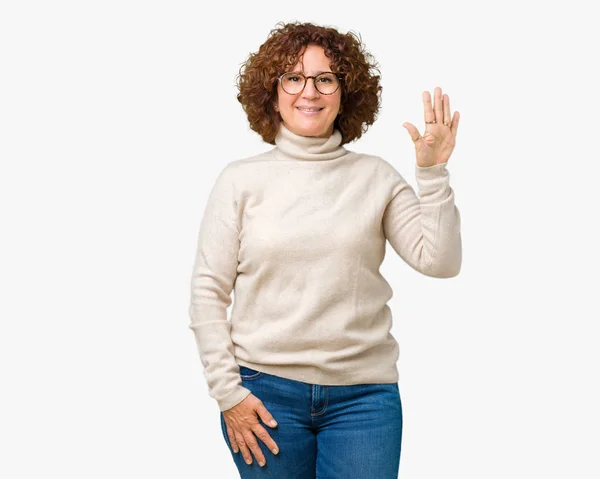 美丽的中年妇女穿着高领毛衣和眼镜在孤立的背景显示和手指指向数字五 同时微笑着自信和快乐 — 图库照片