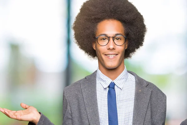 Young african american business man with afro hair wearing glasses Smiling showing both hands open palms, presenting and advertising comparison and balance