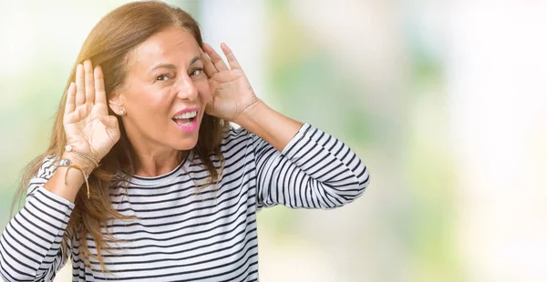 Her ikisi de dinliyoruz izole arka plan üzerinde çizgili süveter giyen güzel orta yaş kadın kulak jest, dedikodu için meraklı eller. İşitme sorunu, sağır