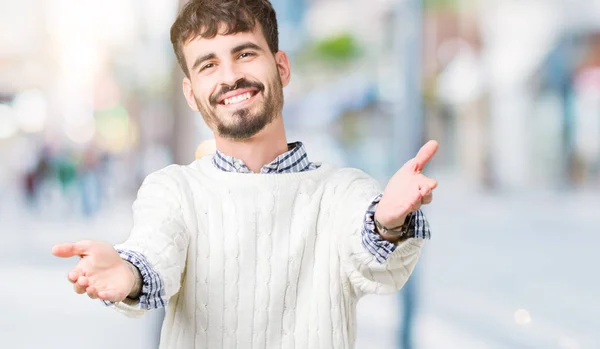 Ung Vacker Man Iförd Vinter Tröja Över Isolerade Bakgrunden Tittar — Stockfoto