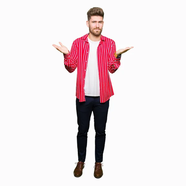 Junger Gutaussehender Mann Rotem Hemd Ahnungslos Und Verwirrt Mit Erhobenen — Stockfoto