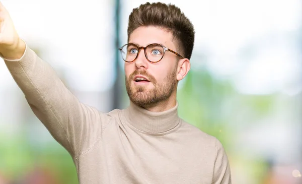 Joven Hombre Negocios Guapo Con Gafas Señalando Con Dedo Sorprendido —  Fotos de Stock