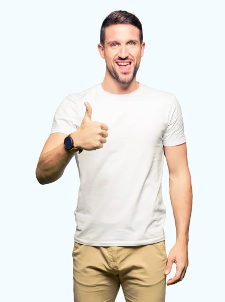 잘생긴 남자가 엄지손가락 손으로 제스처를 캐주얼 티셔츠를 성공을 보여주는 카메라 — 스톡 사진