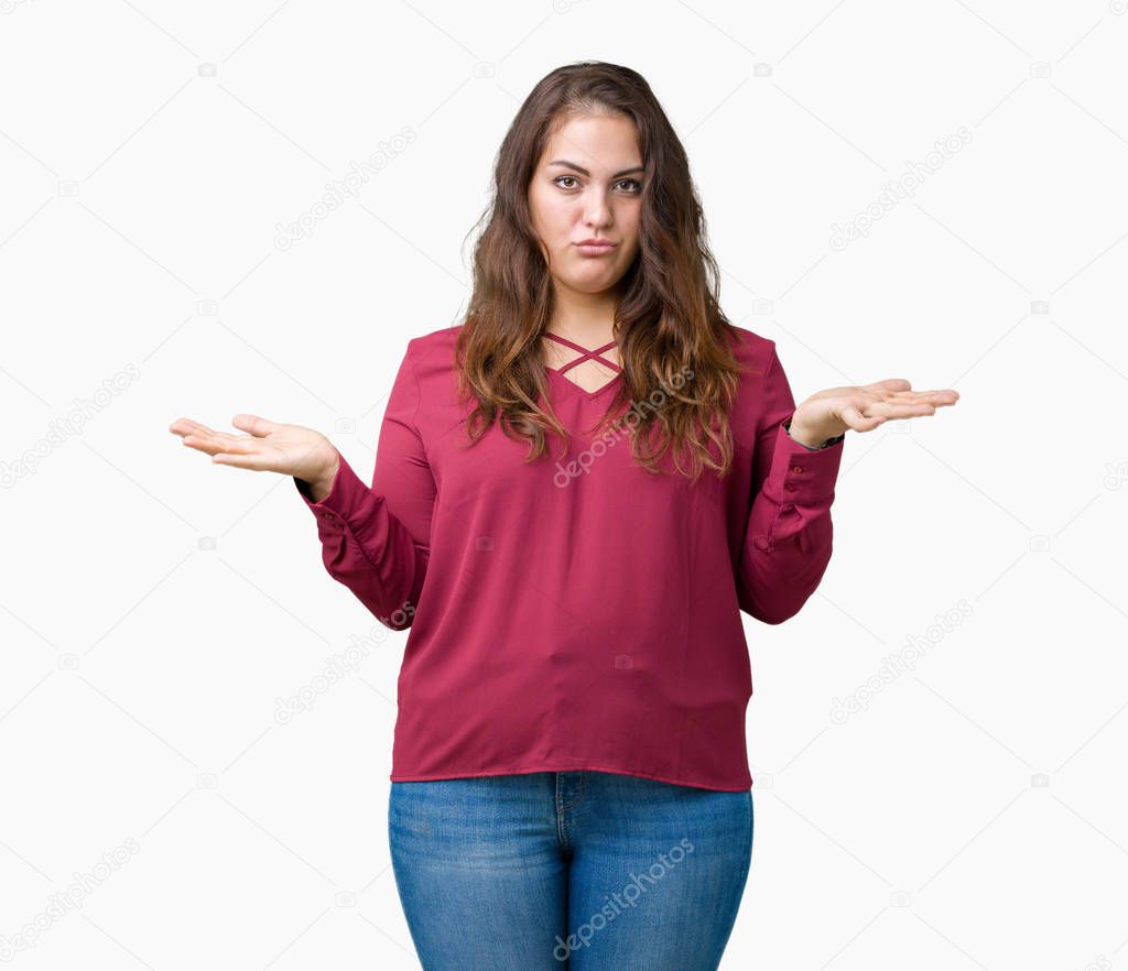 Beautiful plus size young woman over isolated background clueless and confused expression with arms and hands raised. Doubt concept.