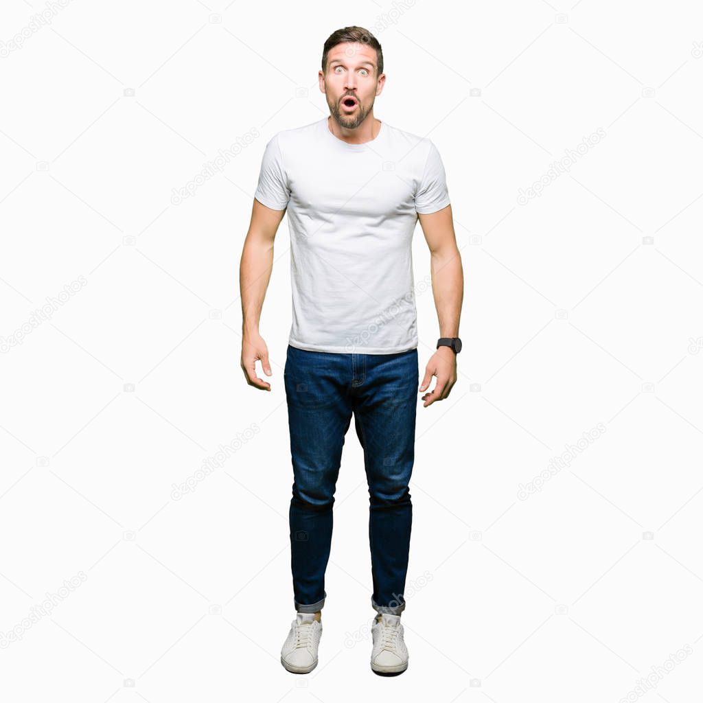 Handsome man wearing casual white t-shirt afraid and shocked with surprise expression, fear and excited face.