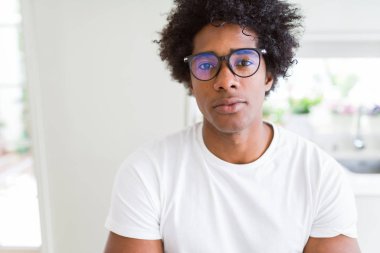 Afrika kökenli Amerikalı adam gevşek ciddi ifade ile yüzünde gözlüklü. Basit ve çapraz silah ile doğal