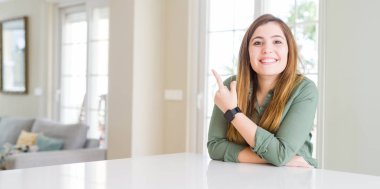 Güzel genç kadın ve neşeli bir gülümseme yüzünü elimle işaret ile ev yan yüzünde mutlu ve doğal ifade ile kadar parmak