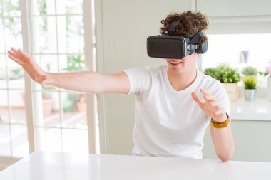 Genç adam eğleniyor evde sanal gerçeklik gözlüklü