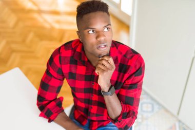 Yakışıklı afro-amerikan erkeğin tepebaşı açısı, çenesi üzerinde soru, dalgın ifade yi düşünüyor. Düşünceli bir yüzle gülümsüyor. Şüphe kavramı.