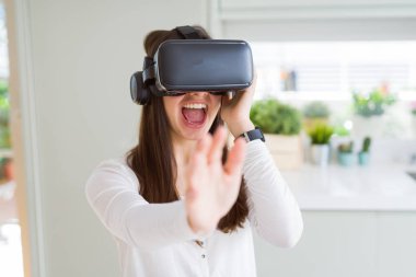 Simülasyon gözlük kulaklık, komik ve şaşırtıcı eğlence kullanarak sanal gerçeklik oyunu oynayan genç kadın