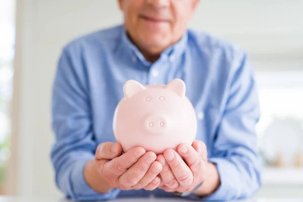 Człowiek Trzyma Skarbonka Ostrożnie Uśmiechnięty Oszczędzając Pieniądze Emeryturę — Zdjęcie stockowe