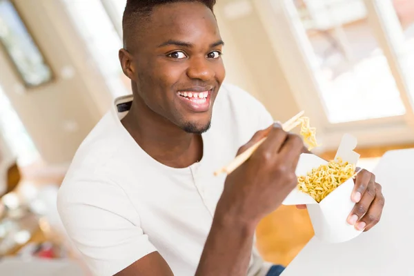 Hombre Africano Guapo Comiendo Fideos Asiáticos Una Caja Entrega Sonriendo — Foto de Stock