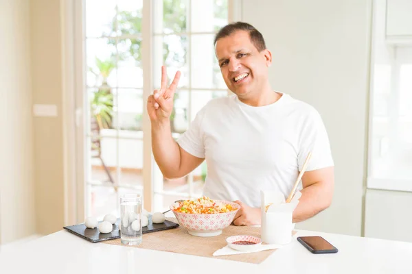 Hombre Mediana Edad Comiendo Comida Asiática Con Palillos Casa Sonriendo — Foto de Stock