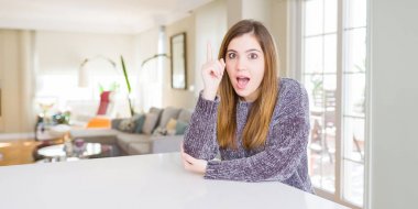 Evde güzel genç kadın başarılı bir fikir ile parmak yukarı işaret. Çıkıldı ve mutlu. Bir numara.