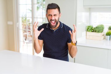 Yakışıklı İspanyol adam evde deli ve deli silah kaldırdı ve kapalı gözleri heyecanlı çığlık ile başarı için kutluyor. Kazanan kavramı