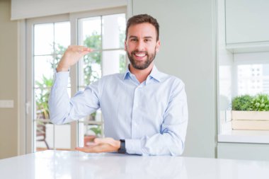 Yakışıklı iş adamı elleri büyük ve büyük boy işareti gösteren gesturing, sembol ölçmek. Kameraya bakarak gülümsüyor. Ölçme kavramı.