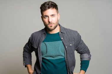 Yakışıklı delikanlı possing ve modelleme gri izole arka plan üzerinde