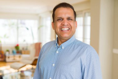 Orta yaş erkek fotoğraf makinesi için evde emin gülümseyen